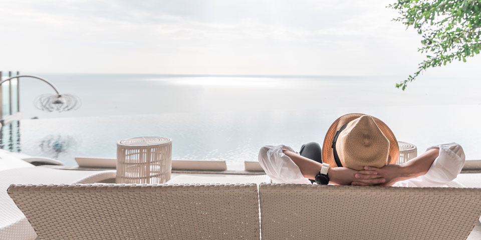woman reclining on a chair in front of the sea