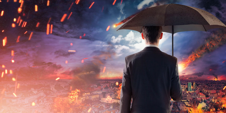 Man standing under an umbrella as fire falls from the night sky